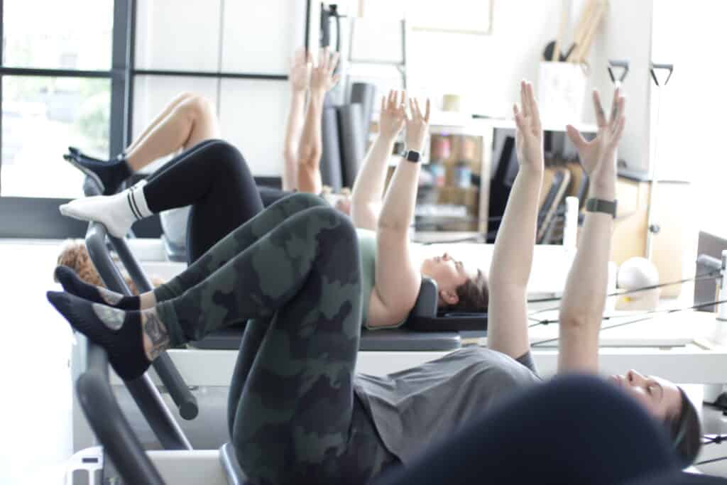 new client unlimited pilates class of people enjoying a reformer workout in Nashville